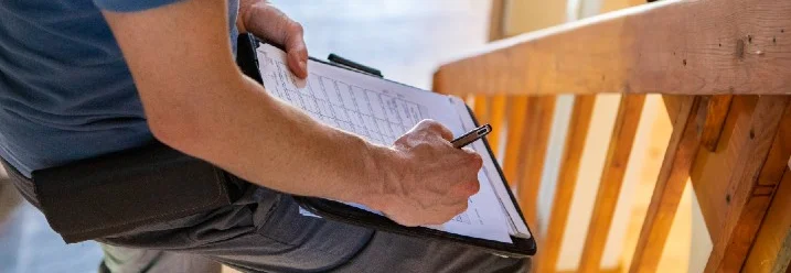 Person füllt Formular auf Holztтєppe aus